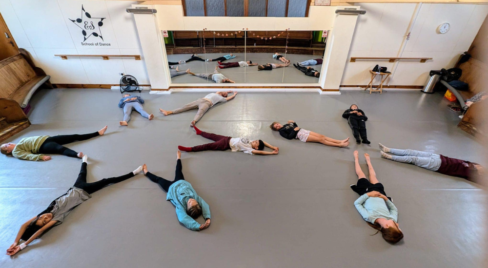 ESSOPA students lying in a star shape across the studio floor during a summer school session